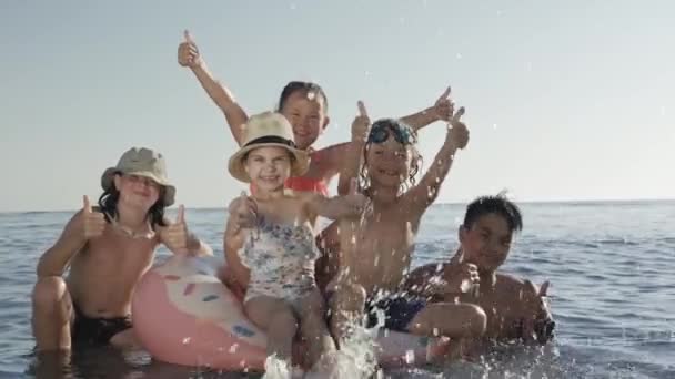 Діти розважаються в морі на літніх канікулах — стокове відео