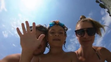 Yaz tatilinde deniz plajında eğlenen mutlu aile.