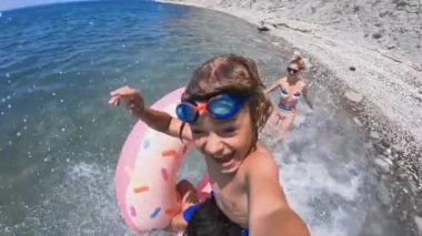 Yaz tatilinde deniz plajında eğlenen mutlu aile.