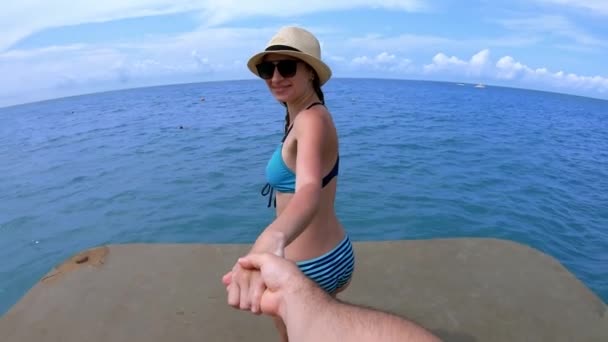 Jonge vrouw in bikini Holding Mans hand, leidt haar vriendje — Stockvideo