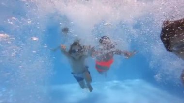 Yüzme havuzuna atlayan ve dalan çocukların su altı manzarası
