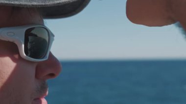 Tatmin olmuş bir adam dağın tepesinde duruyor ve uzaklığa bakıyor.