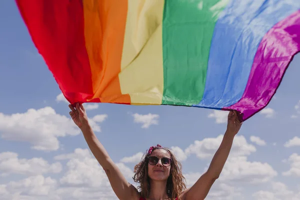 Mujer Sosteniendo Bandera Del Arco Iris Gay Sobre Cielo Azul — Foto de Stock