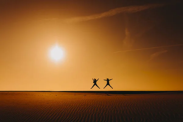 Silhueta Duas Mulheres Amigas Pulando Praia Pôr Sol Durante Hora — Fotografia de Stock