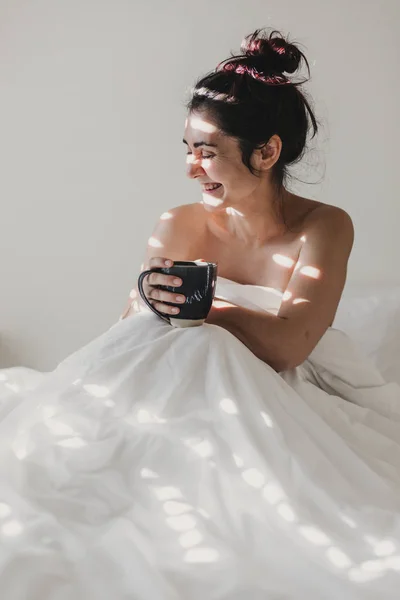 Mujer Desnuda Cubierta Sábanas Blancas Sentada Cama Disfrutando Una Taza —  Fotos de Stock