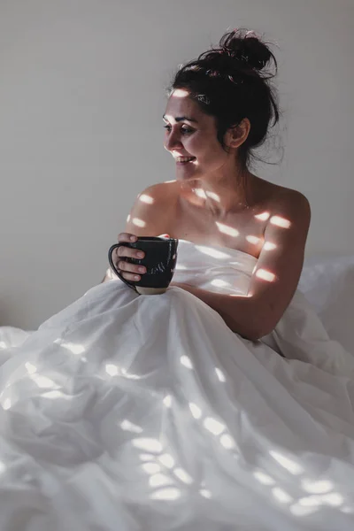 Mujer Desnuda Cubierta Sábanas Blancas Sentada Cama Disfrutando Una Taza —  Fotos de Stock