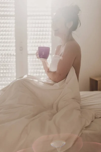 Wanita Telanjang Ditutupi Dengan Seprai Putih Duduk Tempat Tidur Dan — Stok Foto