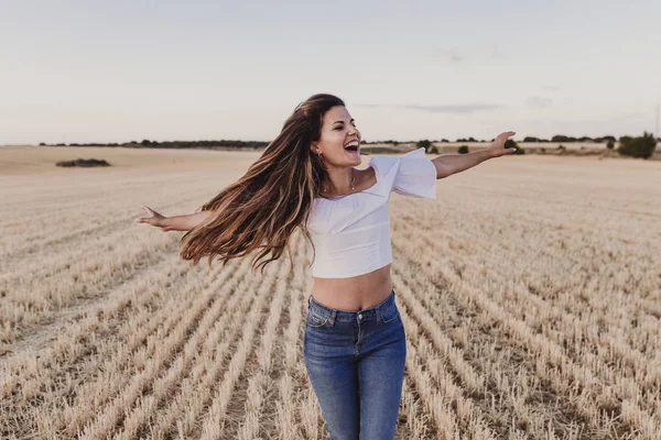 Summer Girl sarı alanda doğanın tadını çıkarıyor. Güzel genç kadın açık havada dans ediyor. Rüzgarda uzun saçlar. Mutluluk ve yaşam tarzı. Geri görünüm