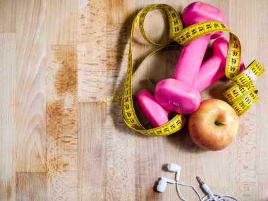 pembe ağırlık ve sarı şerit metre ve bakış açısı yukarıdan bir elma ile natürmort. Fitness. spor. kavram. kopya alanı solda