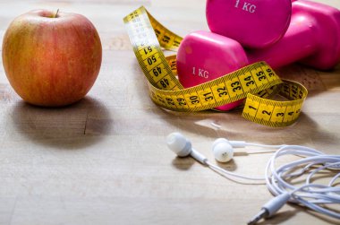 Natürmort ve elma, pembe ağırlık, sarı şerit metre ile yakın. Fitness ve yaşam tarzı kavramları.