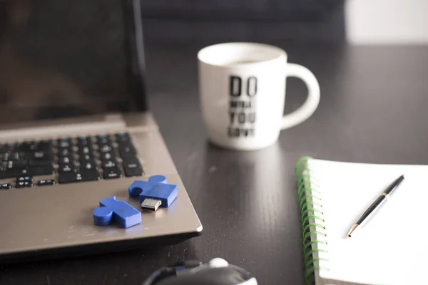 Defter, kalem ve kahve siyah ofis masası üzerinde beyaz bir kupa ile natürmort. iş sembolü