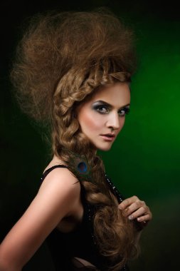 tavus kuşu tüyü el ve yaratıcı saç modeli ile güzel kadın