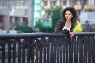 Güzel genç esmer kız bir şehir Köprüsü üzerinde.