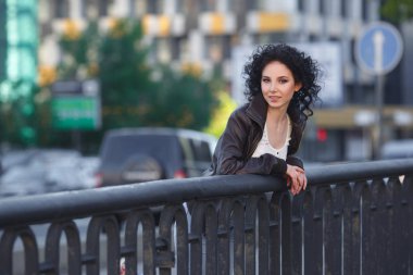 Güzel genç esmer kız bir şehir Köprüsü üzerinde.