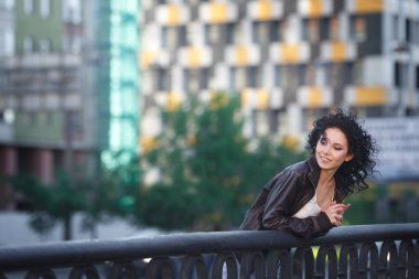 Güzel genç esmer kız bir şehir Köprüsü üzerinde.