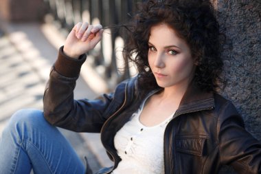 Şirin esmer kız yakınındaki bir çit sokakta oturuyor.