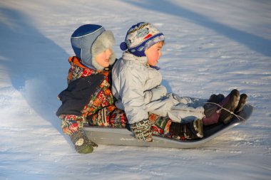 Bir kış günü tepeden halletme iki neşeli çocuk.
