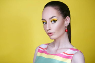 Sarı zemin üzerine parlak makyaj kadınla görünümü Kapat