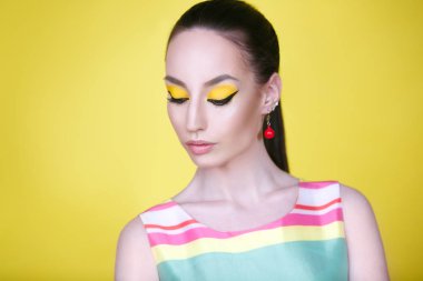 Sarı zemin üzerine parlak makyaj kadınla görünümü Kapat