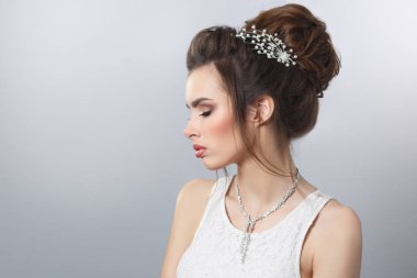 Zarif gelin saç ve makyaj gri arka plan üzerinde güzellik portresi.