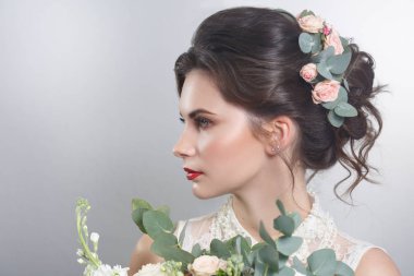 Sevimli gelin buketi gri arka plan üzerinde elinde ile portresi.