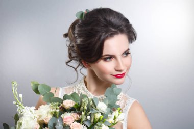 Sevimli gelin buketi gri arka plan üzerinde elinde ile portresi.