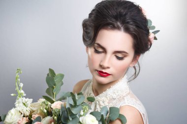 Sevimli gelin buketi gri arka plan üzerinde elinde ile portresi.