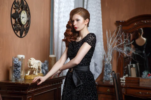 Siyah elbiseli şömine yakın klasik iç zarif kadın.