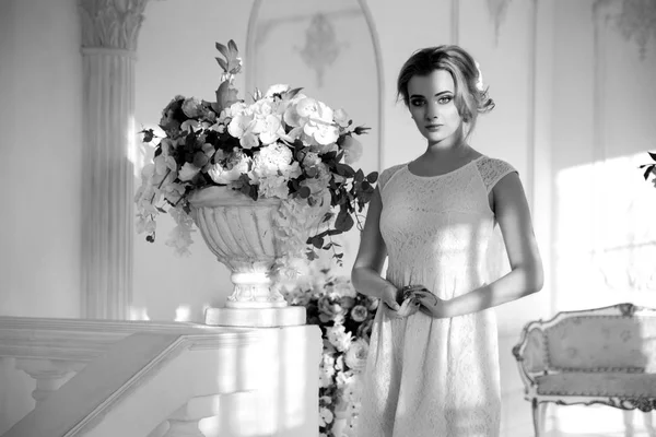 Black and white portrait of a happy blonde bride in a light interior.