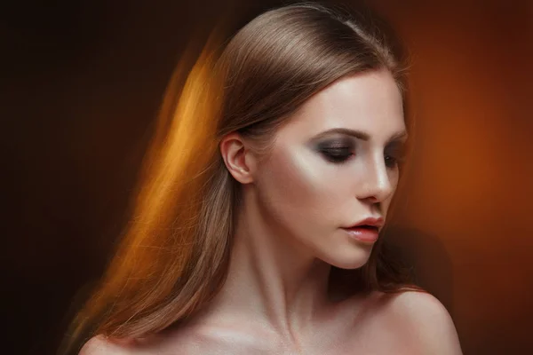 Mysterious beauty portrait of a chic woman with long straight hair, mixed light.