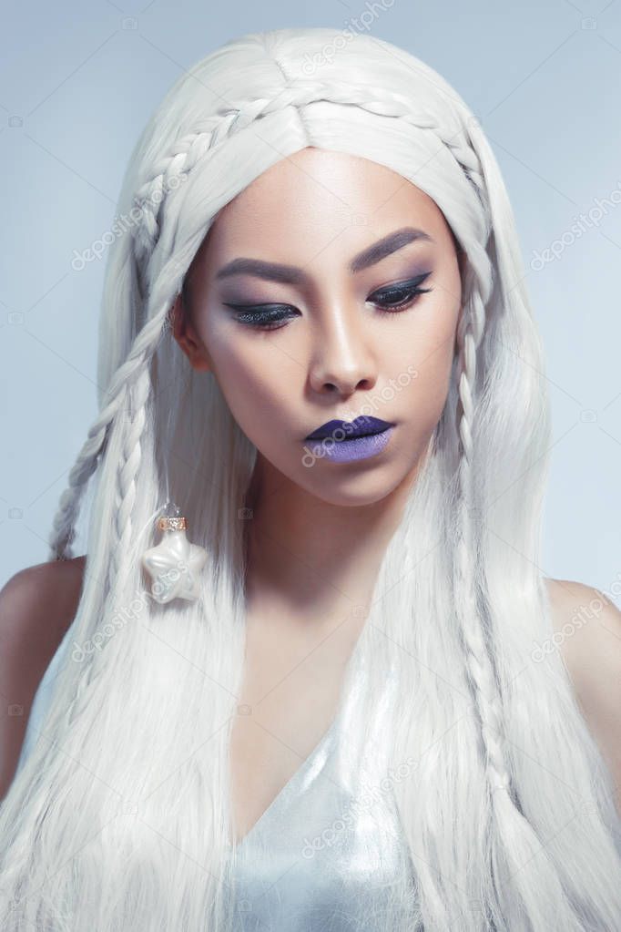 Beauty portrait of a beautiful Asian girl with long white hair isolated on a gray background.