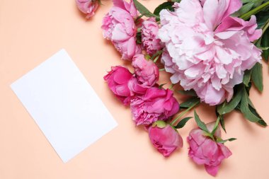 Bir buket pembe peonies ve bir beyaz kağıt somon balığı renginde bir arka plan üzerinde aittir .