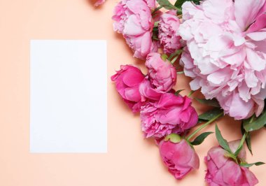 Bir buket pembe peonies ve bir beyaz kağıt somon balığı renginde bir arka plan üzerinde aittir .