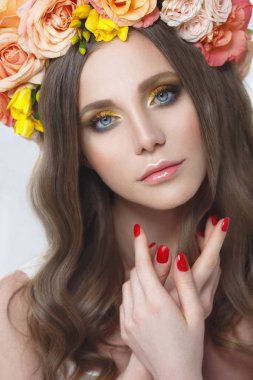 Gül parlak bir çelenk ve parlak sarı-turuncu makyaj ile güzel bir kız moda güzellik portresi.