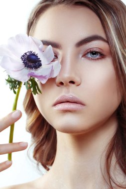 Beyaz arka plan üzerinde bir göz kapsayan pembe anemon çiçeği ile şirin kız portresi güzellik izole.