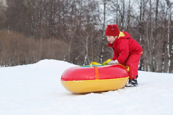 Uma Criança Uma Tuba Vermelha Tubulação Parque Inverno — Fotografia de Stock