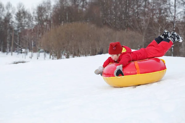 Niño Una Tuba Roja Tubo Parque Invierno —  Fotos de Stock