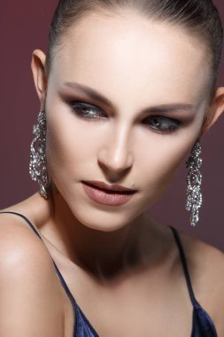 akşam makyaj ve koyu zemin üzerinde zarif küpe ile güzel bir kadın portresi