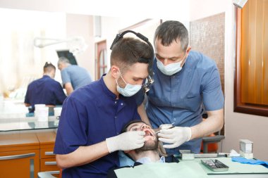 Dişçi diş ofiste hasta ile çalışma Yardımcısı ile