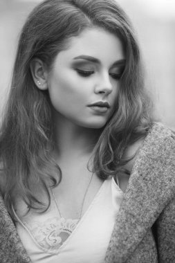 Açık havada gri paltolu güzel genç kadın portresi