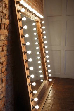 Çatı katında ışık lı bir çerçevede büyük bir ayna duruyor.