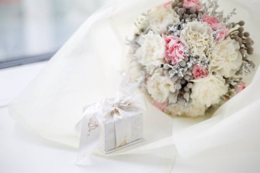 Düğün buketi ve yeni evlilerin yüzükleri.
