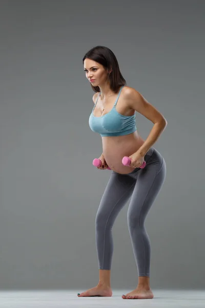 Szczupła Kobieta Ciąży Jest Zaangażowany Fitness Izolowane Szarym Tle — Zdjęcie stockowe
