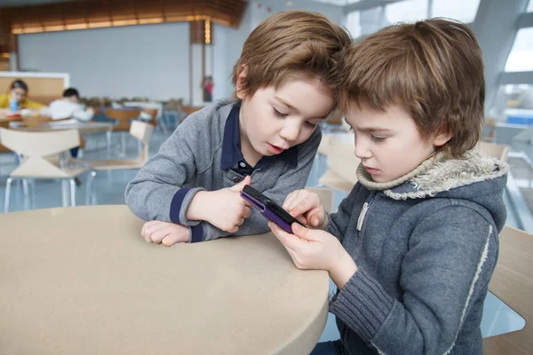 Two Boys Emotionally Play Smartphone Cafe Table — Stock Photo, Image