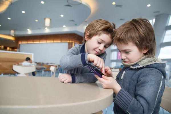 Two Boys Emotionally Play Smartphone Cafe Table — Stock Photo, Image