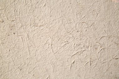 Desensel arkaplan, bej rengine boyanmış yığın etkisi olan alçı..