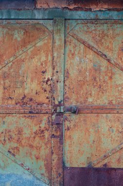 Eski paslı metal bir yüzey üzerindeki desenli yeşil boya çatlamış. Kapının bir parçası..