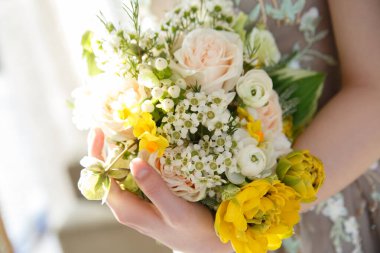 Gelin elinde narin bir bahar düğün buketi tutuyor..