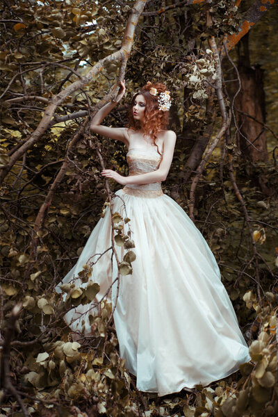 Portrait of bride in long flowing dress in mysterious forest