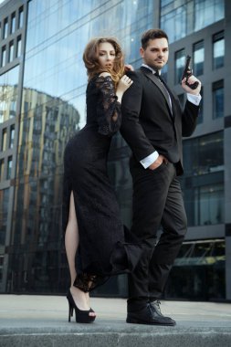 Elinde tabancaları olan zarif bir adam güzel bir kızı korur..